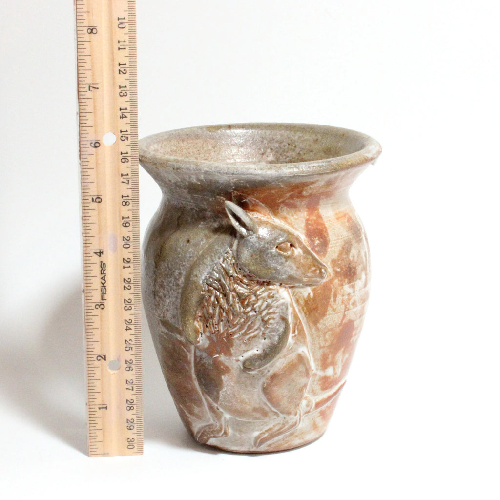 Ceramic vase with a kangaroo design next to a ruler for scale on a white background