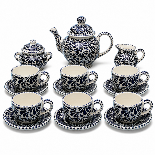 Ceramic tea set with black floral patterns on a white background